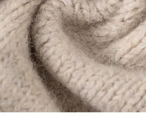 Detailopname van beige grof gebreide stof met zacht huidvriendelijk materiaal