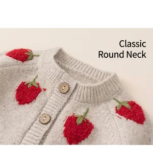 Detail van de halslijn van het babyvestje met aardbeienpatroon en houten knoop