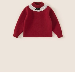 Dettaglio del cardigan rosso da bambina con colletto a balze e fiocco nero