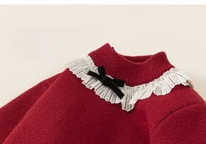 Dettaglio del maglione rosso in maglia con colletto in pizzo e fiocco in velluto
