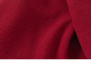 Macro dettaglio del morbido tessuto a maglia rosso con trama fine e trama liscia