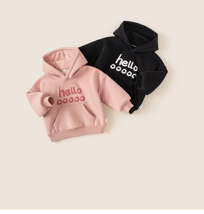 Flat lay of pink and black kids hoodies featuring kangaroo pockets and hello graphics