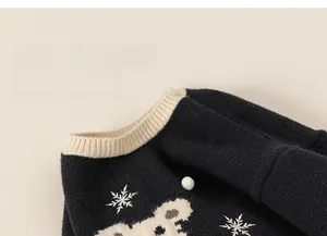 Detail of soft knit navy sweater with white ribbed neckline and cartoon bear pattern