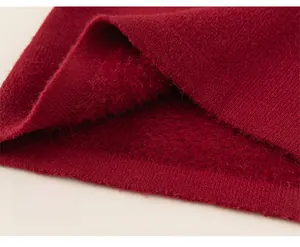 Dettaglio del maglione rosso per bambina con fodera in pile termico e morbido orlo a costine
