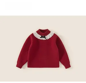 Dettaglio del maglione rosso in maglia con colletto a balze bianco e fiocco nero