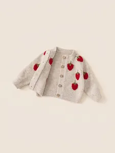 Meisjes gebreid vest in havermoutkleur met aardbeienborduurwerk en mooie houten knopen