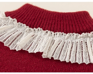 Dettaglio di un maglione rosso a maglia con colletto in pizzo bianco e trama fine