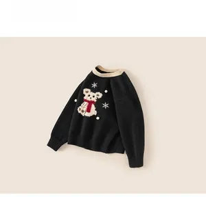 Detail of black knit sweater featuring a cute cartoon bear with white 3D pom-pom snowflakes