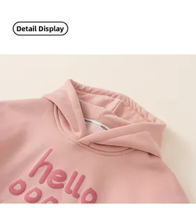 Detailed close-up of pink hooded sweatshirt neckline with 3D hello letter embroidery