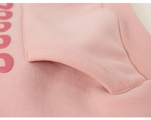 Macro view of pink hoodie pocket with 3D embossed lettering and fine ribbed edge