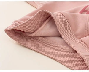 Detail of pink hoodie showing ribbed cuffs and soft warm fleece lining texture