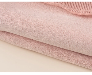 Close-up of soft pink polar fleece fabric with neat ribbed edge detail on hoodie