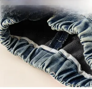 Détail de la taille élastique et de la doublure polaire grise sur un jean bleu foncé pour fille