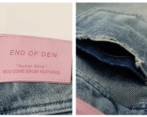 Détail de l'étiquette en cuir rose et des coutures de poche sur le jean en denim bleu