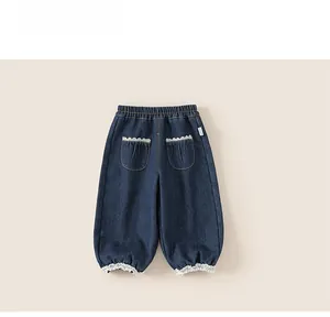 Détail du pantalon en jean bleu foncé pour fille avec taille élastique et bord en dentelle