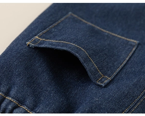 Détail de la doublure polaire et des coutures jaunes sur le jean bleu pour fille