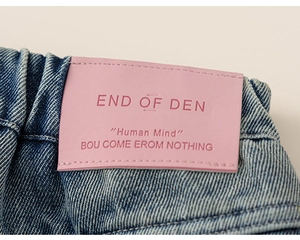 Détail du jean fille montrant l'étiquette en cuir rose et la taille élastique plissée