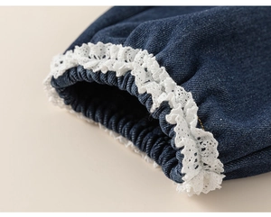 Vue détaillée du jean avec bordure en dentelle blanche et poignets élastiques bleus