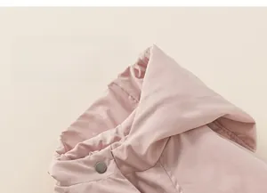 Close-up of pink padded winter jacket with metal button and soft textured fabric