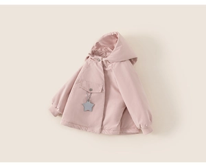 Detail of pink hooded girls coat featuring a flap pocket and star charm accessory