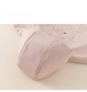 Detailed close-up of pink hooded winter coat for girls showing quilting and pocket buttons