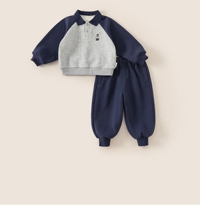Detail of kids navy blue and grey fleece sports set featuring a small bear embroidery