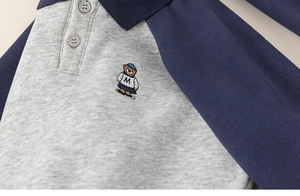 Close-up of kids polo sweatshirt with bear embroidery and raglan sleeves detail