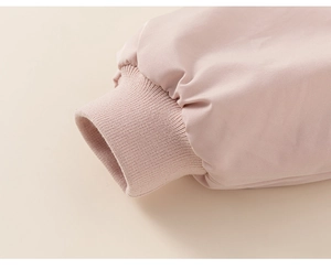 Close-up of pink winter coat sleeve showing ribbed knit cuffs and woven fabric texture