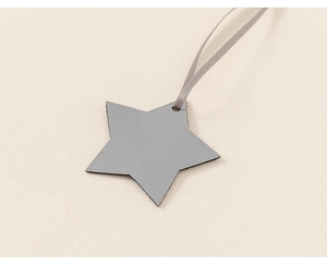Close-up of a grey star-shaped decorative tag with a satin ribbon on a warm beige background