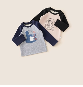 Dettaglio di magliette raglan in morbido cotone con stampe a cartoni e etichette