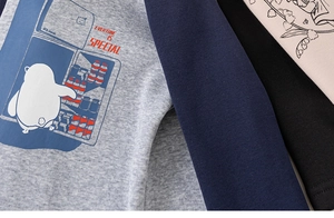 Dettaglio della stampa pinguino e cuciture maniche raglan su calda maglia bimbi