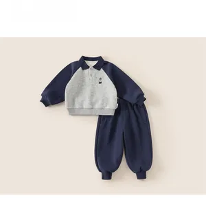 Detail of kids sportswear set featuring grey blue contrast colors and bear embroidery