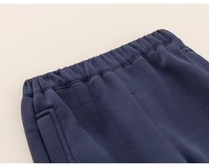 Detail of navy blue kids' sweatpants showing elastic waistband and stitching