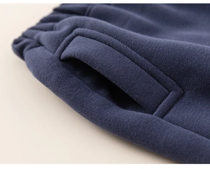 Detailed view of elastic waistband and reinforced side pockets on navy cotton joggers