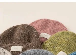 Detailed close-up showing colorful mixed-yarn knit textures and labels on soft winter beanies