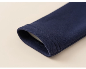 Dettaglio dei polsini blu navy con doppia cucitura su caldo tessuto in cotone per bimbi