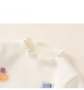 Detailed close-up of white knit collar with ruffle edges and colorful heart embroidery