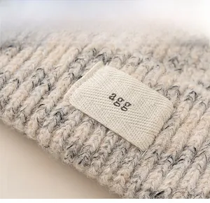 Close-up of thick mixed-knit beanie texture and decorative agg letter fabric patch