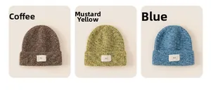 Detailed view of knitted beanies in coffee, mustard, and blue with egg patch