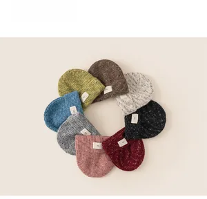 Collection of mixed-knit beanies in eight colors with minimalist square logo labels