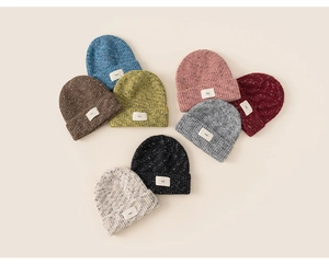 Detailed view of knitted beanies in multiple colors with RSS letter fabric patches
