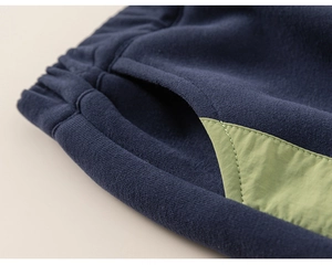 Detail of boys' navy joggers with elastic waistband and green side pocket stitching