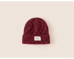 Close-up of wine red knit beanie showing mixed gray yarn texture and agg label detail