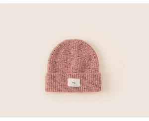 Detail shot of a pink knitted beanie for girls with a stylish agg letter woven patch