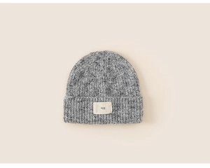 Detail of grey rib-knitted beanie featuring a woven agg letter label on the front cuff