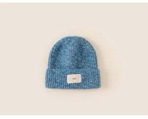 Detail showing blue mixed knit texture and woven label on a children's warm winter beanie