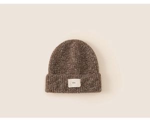 Close-up of brown mixed-knit beanie with a woven letter patch on the folded brim