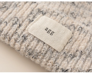 Detail of mixed-knit texture on a warm winter beanie featuring a fabric label tag