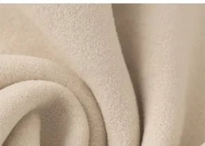 Gros plan sur la texture douce du tissu polaire beige montrant un matériau de qualité