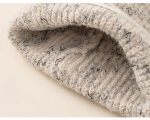 Close-up detail of beige and grey thick knit fabric with textured ribbed knitting pattern